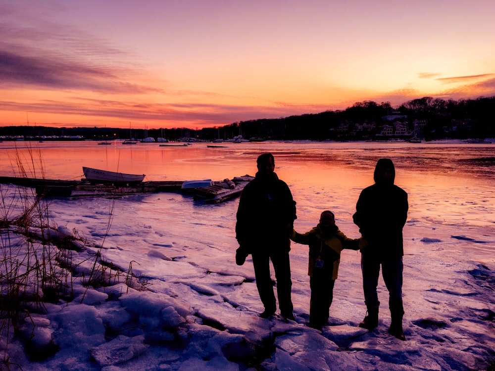 three person standing near boat