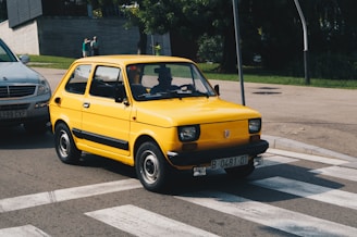 yellow car on concrete road during daytime