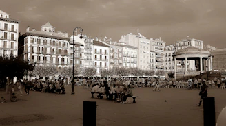 A vintage sepia-toned photograph of a historic town square bustling with people.