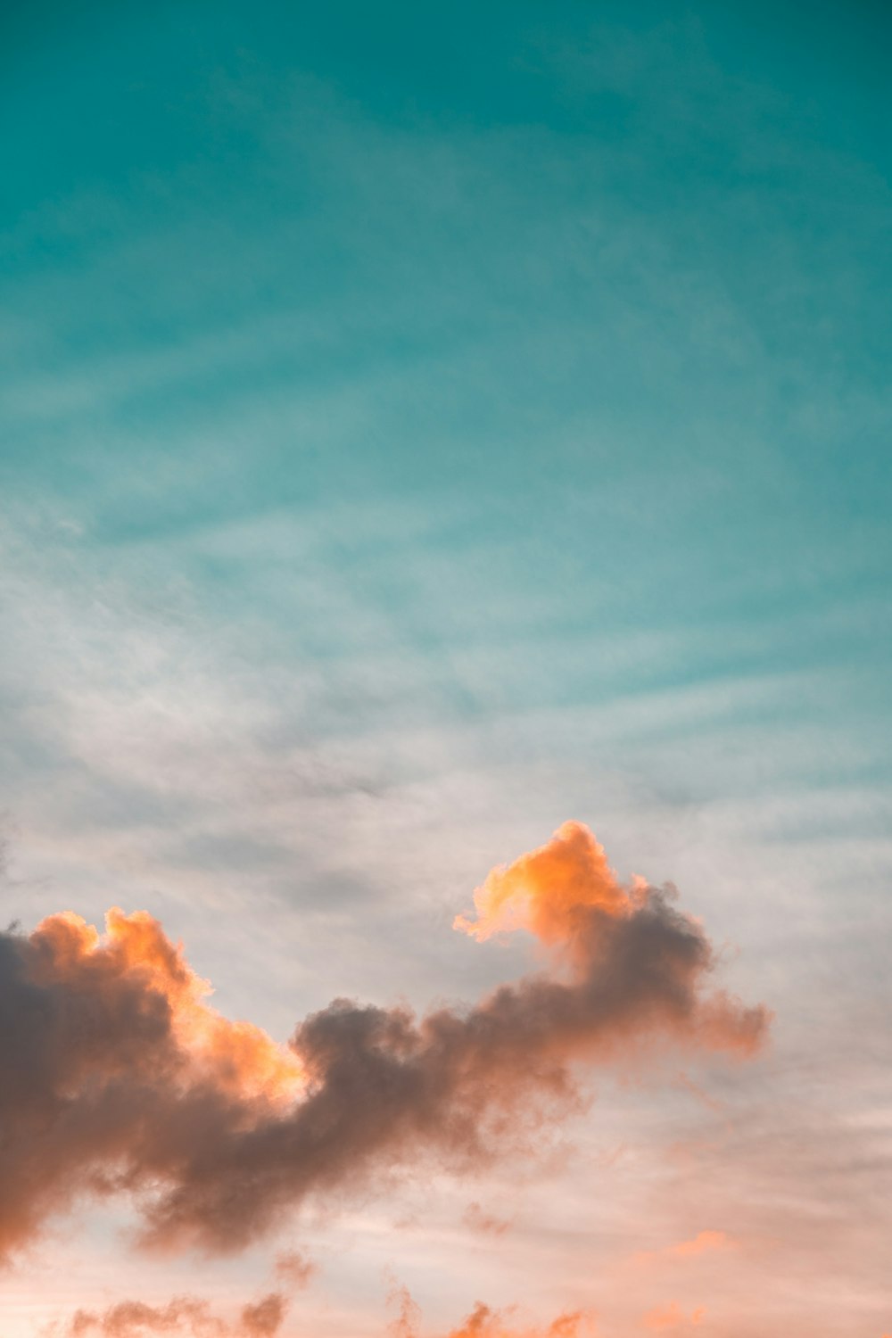 a plane flying in the sky at sunset