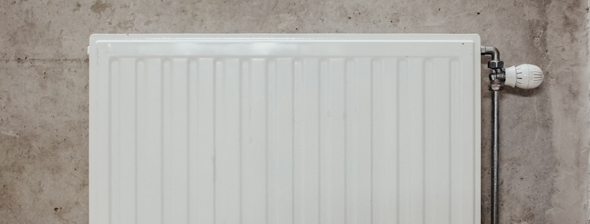 white metal panel heater on gray concrete wall