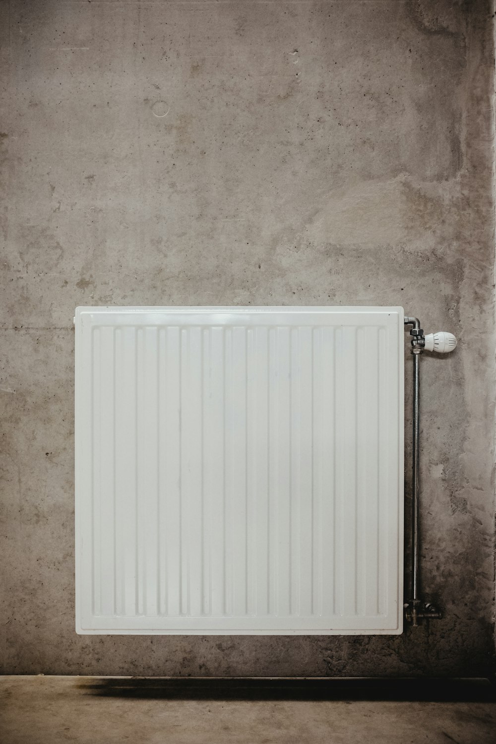 white metal panel heater on gray concrete wall