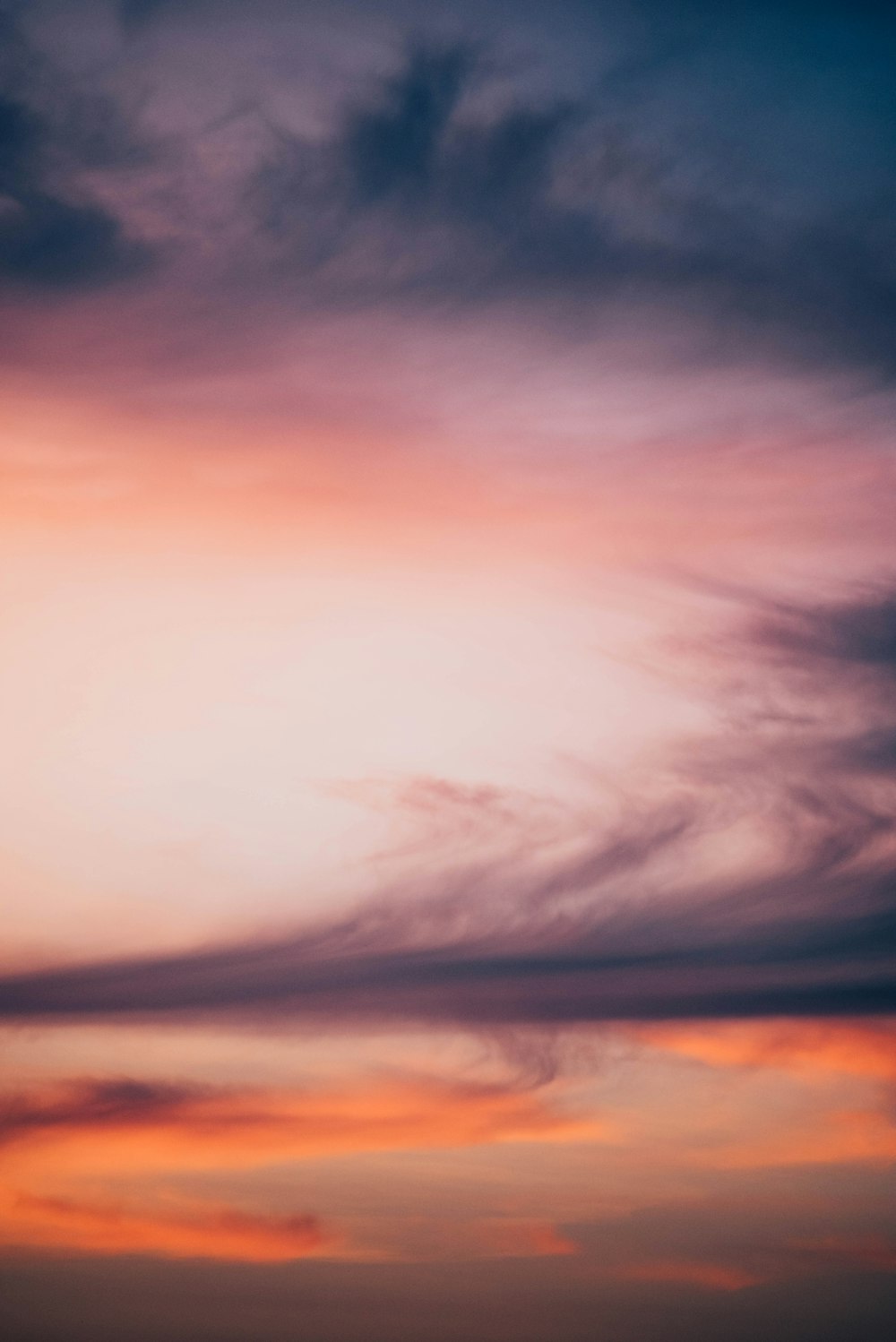 a plane flying in the sky at sunset