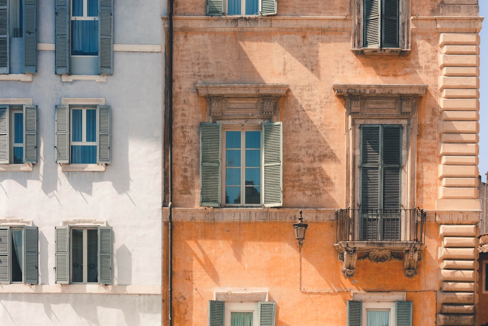 brown building beside white building