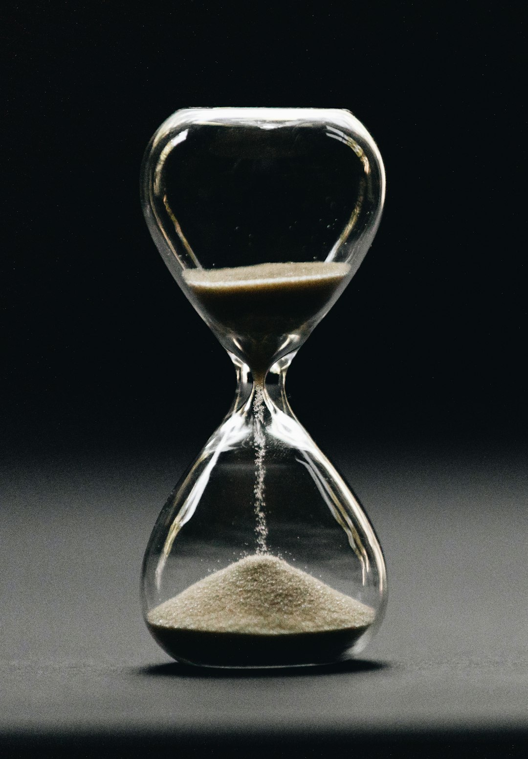 An hourglass with sand running through it, standing in for a daily AI message allowance draining as you build