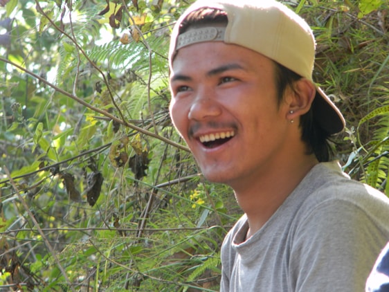 A smiling tour guide welcoming visitors on a lush green trail in Fernando de Noronha.