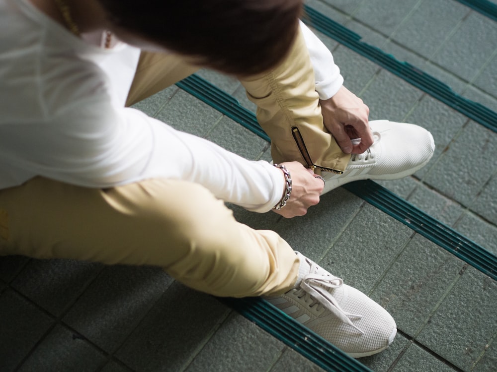 person sitting and zipping his yellow pants