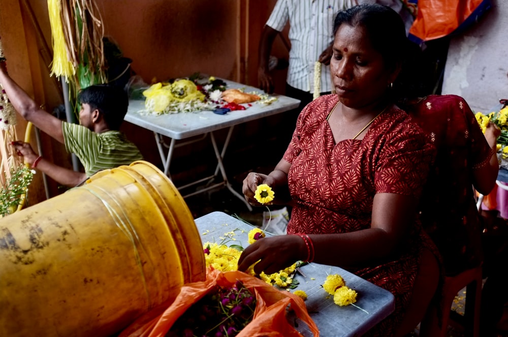 mujer sosteniendo flores de pétalos amarillos