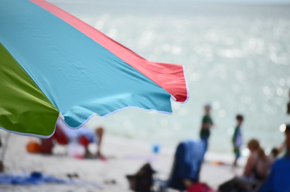 sombrilla de playa azul, roja y verde en primer plano