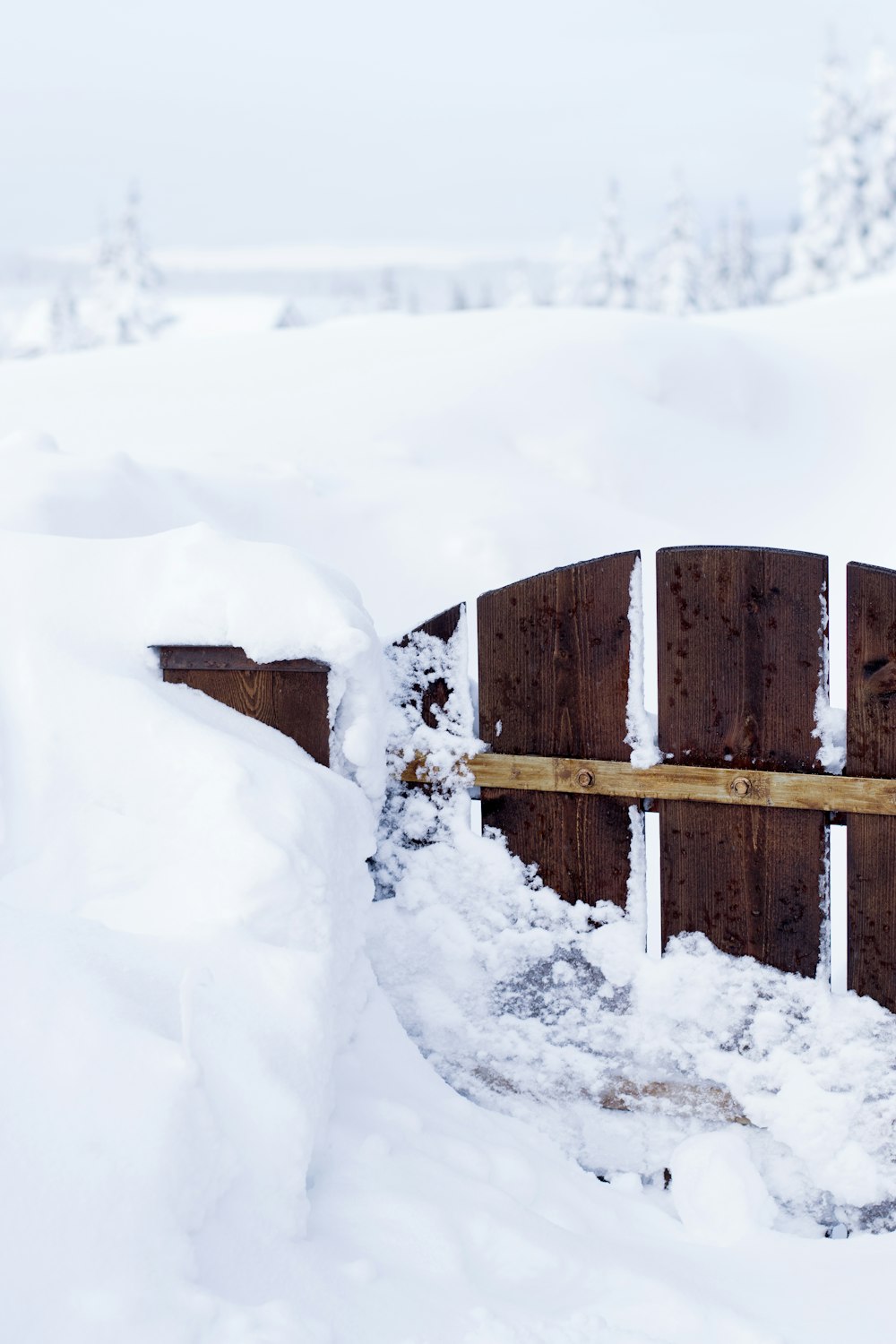 close brown wooden gate surrounding snow