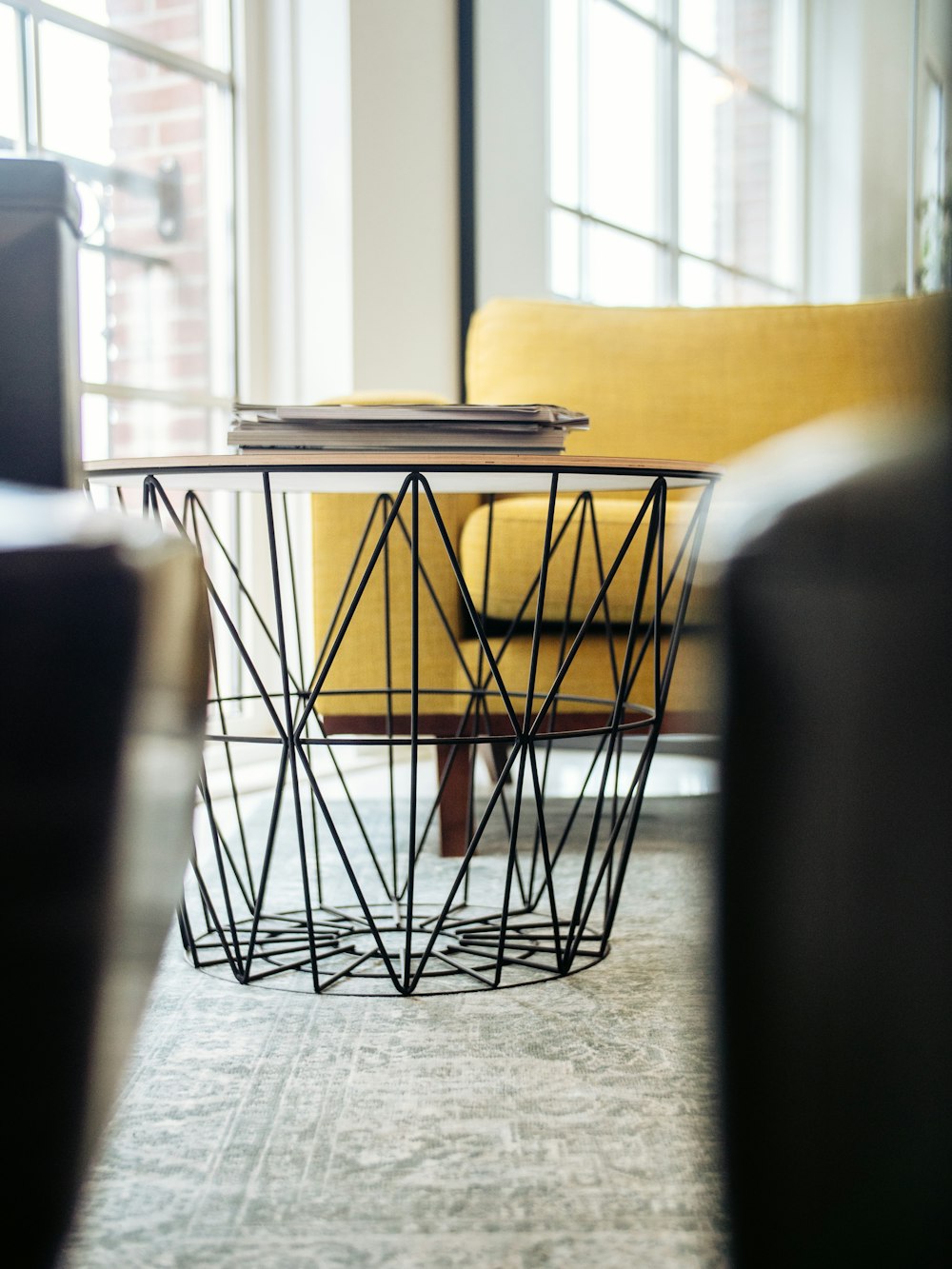 Fotografía de enfoque selectivo de la mesa de café al lado de la silla del sofá