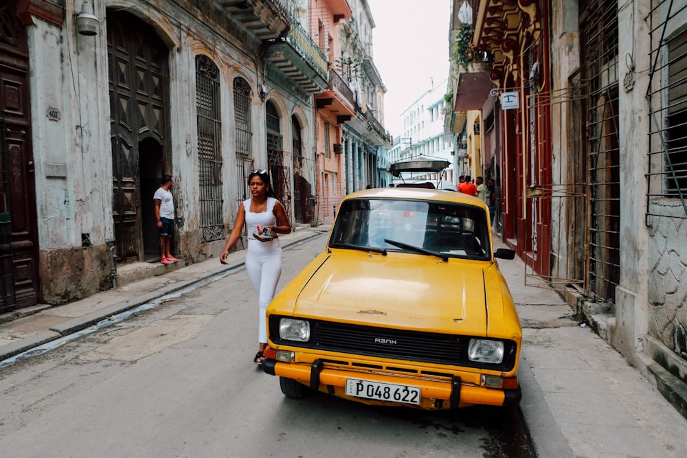 yellow Tofas Murat parked beside white building