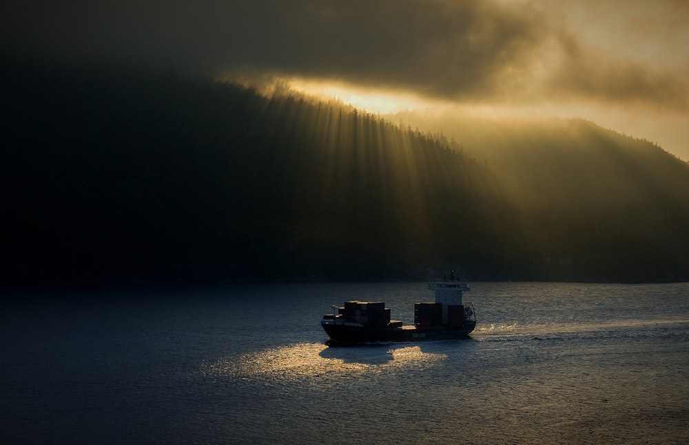 Due navi sullo specchio d'acqua sotto cieli nuvolosi durante l'ora d'oro