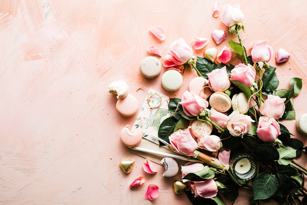 マカロンとピンクのバラの花のフラットレイ写真