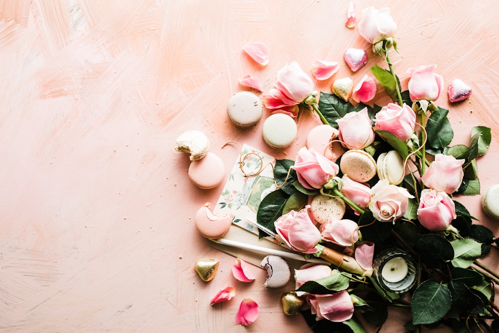 flat-lay photography of macaroons and pink rose flowers