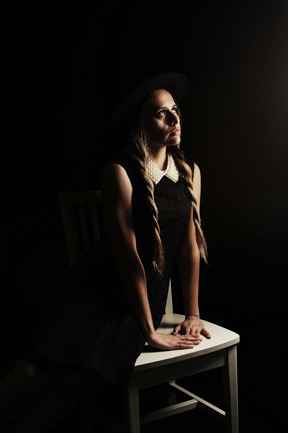 woman looking up sitting on white wooden chair