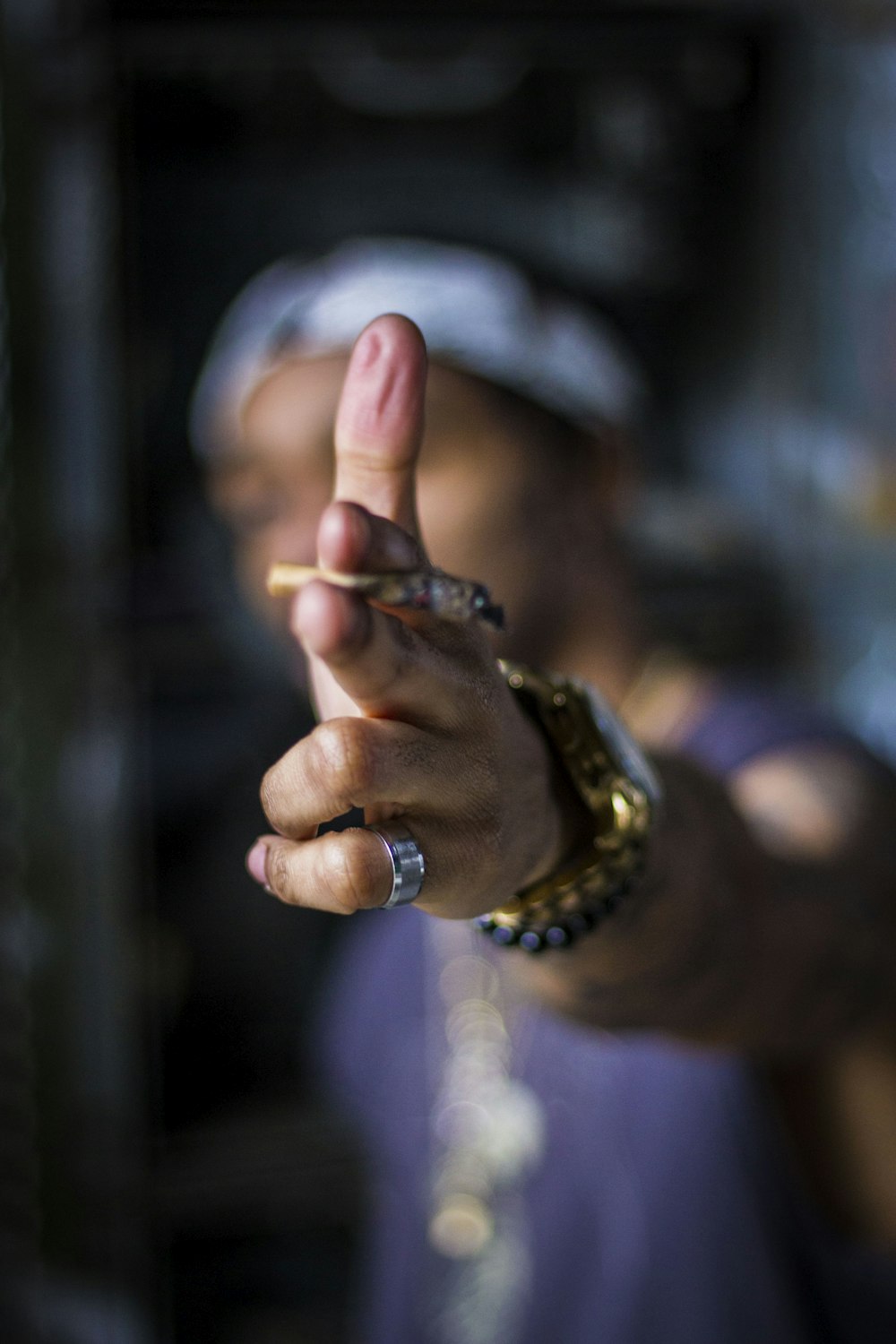 person holding cigarette stick on left hand