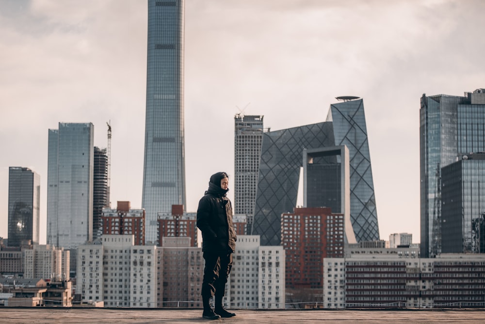 man standing in front of tall buildings