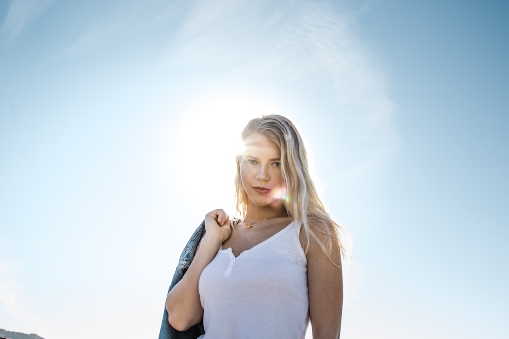 woman carrying blue jacket on her back outdoors