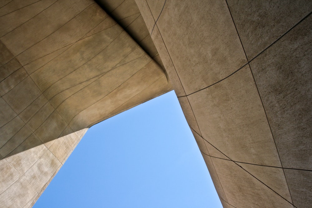 looking up at the side of a building with a blue sky in the background