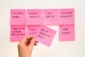 person holding pink sticky note
