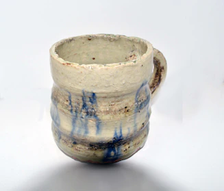 Close-up of a handmade ceramic mug with a bright glaze and textured surface