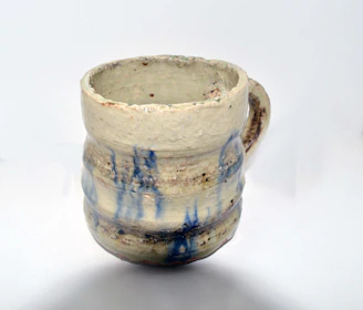 Artisan ceramic mugs showcasing a variety of textures and glazes in warm tones.
