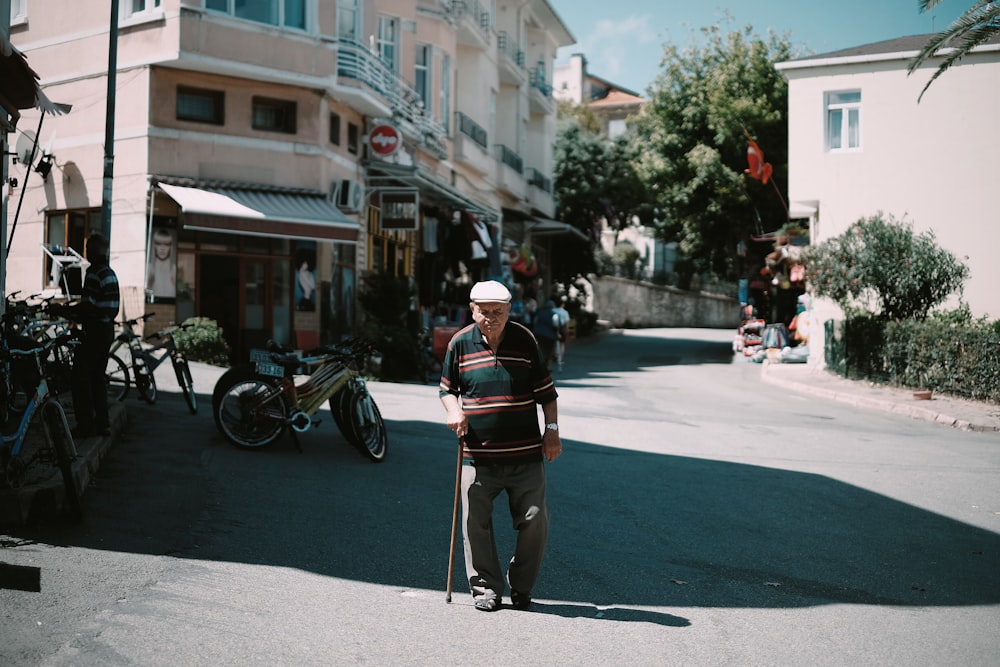 uomo che cammina mentre tiene il bastone durante il giorno