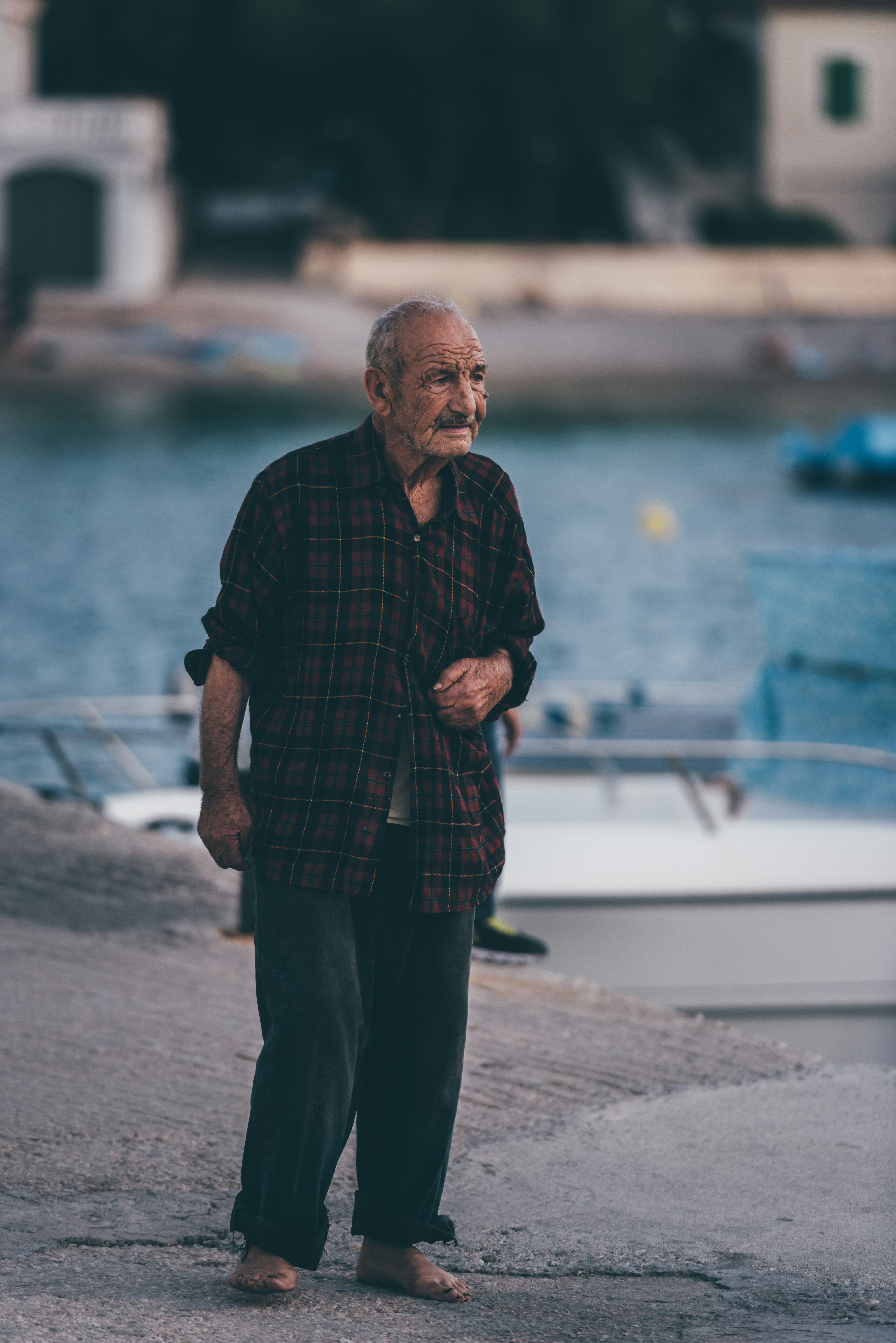 man standing on gray concrete floor near body of water