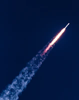 An aerial view of a rocket soaring into the sky.