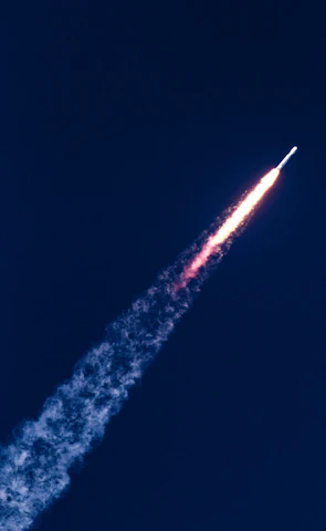 An aerial view of a rocket soaring into the sky.