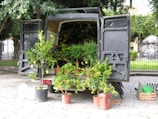 A van parked outside a community building with tools ready for garden maintenance