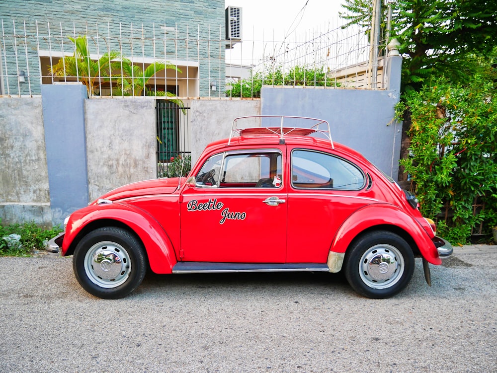 Estacionamiento de escarabajos rojos frente a la casa