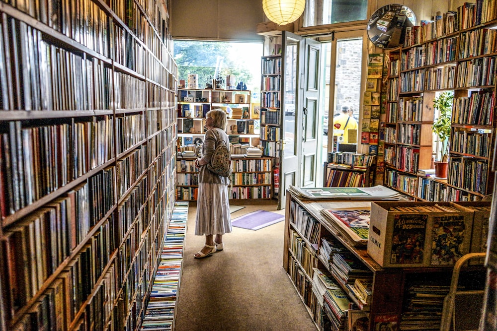 mulher dentro da biblioteca olhando para os livros