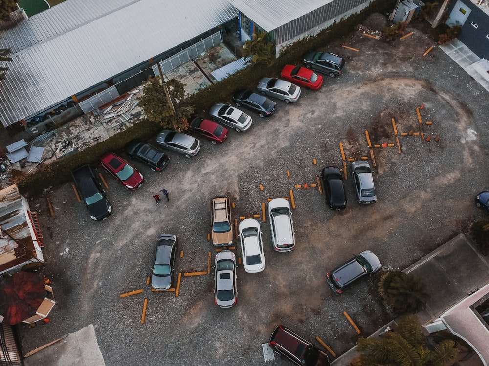 fotografia aérea de veículos variados estacionados ao lado do prédio durante o dia