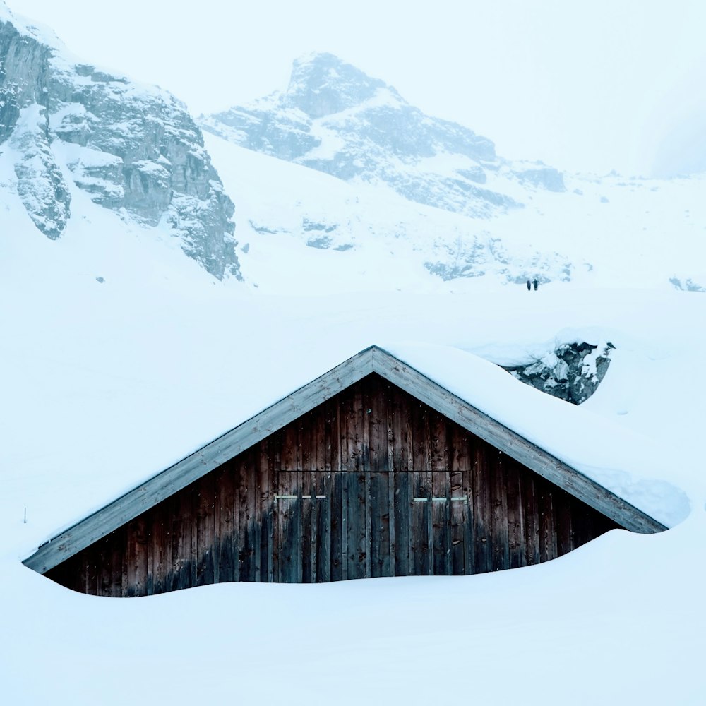 maison en bois marron recouverte de neige