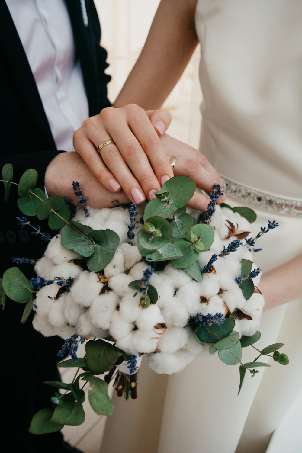 two person holding hands on white flower