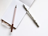 two white and beige pens on white paper
