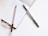 A spiral notebook with lined pages is open, accompanied by two pens. The pen on the left has a checkered design, and the pen on the right features gold polka dots. The background is a clean, white surface.