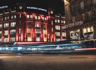 Night view of a retail window glowing with vivid LED visuals in a modern shopping street.