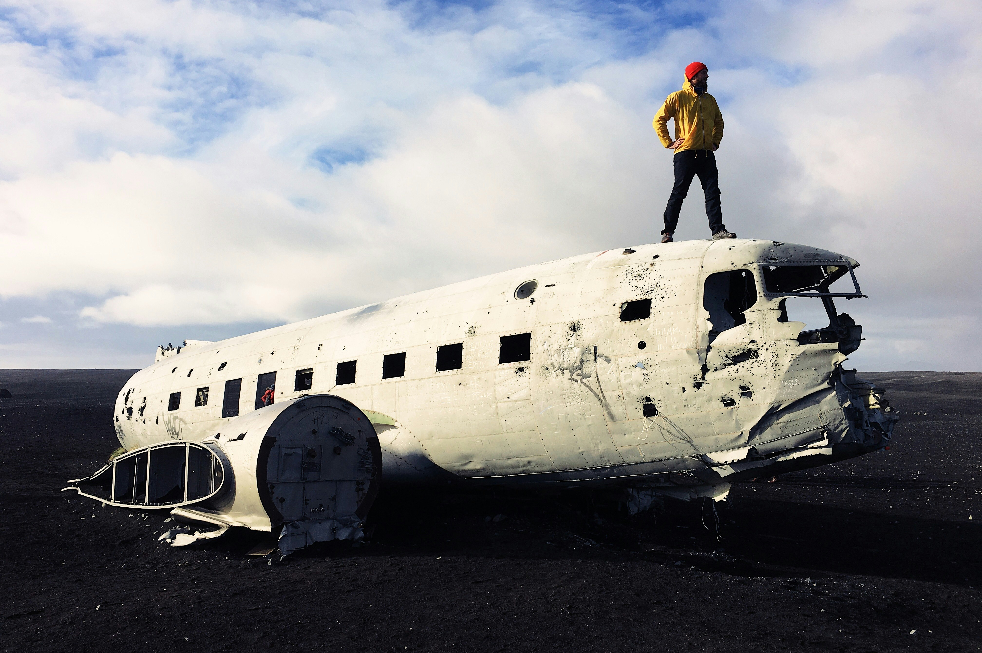 man standing on white abandoned plane under white sky