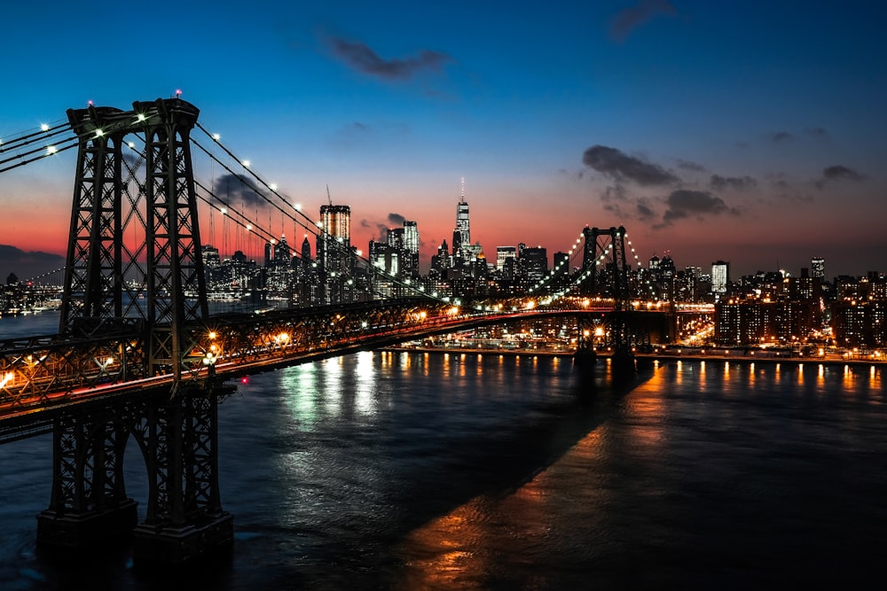 lighted cable bridge near high-rise buildings