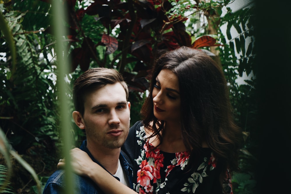 man in blue top carrying woman in floral top