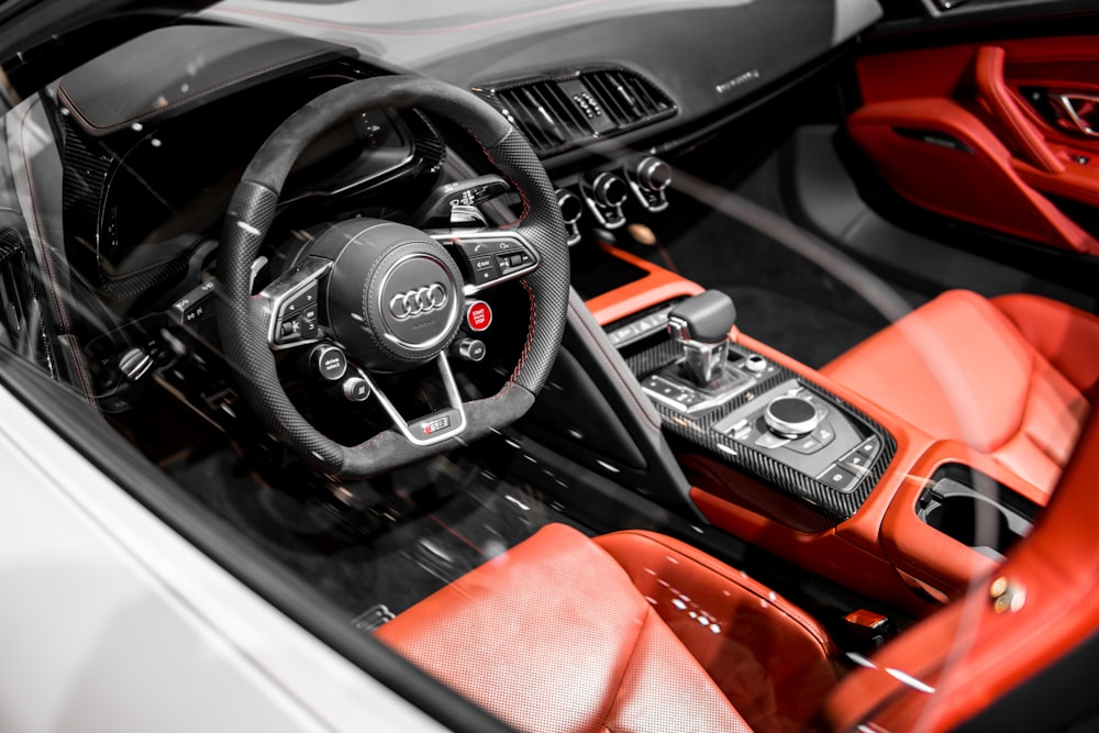 photographie en gros plan de l’intérieur d’un véhicule Audi rouge et noir