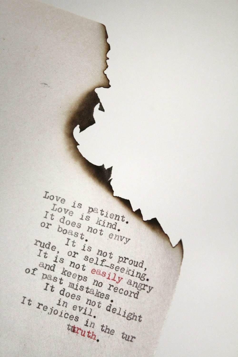 Love is patient Love is kind printed on burned paper