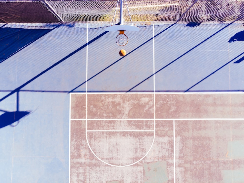 an overhead view of a tennis court with a ball on it