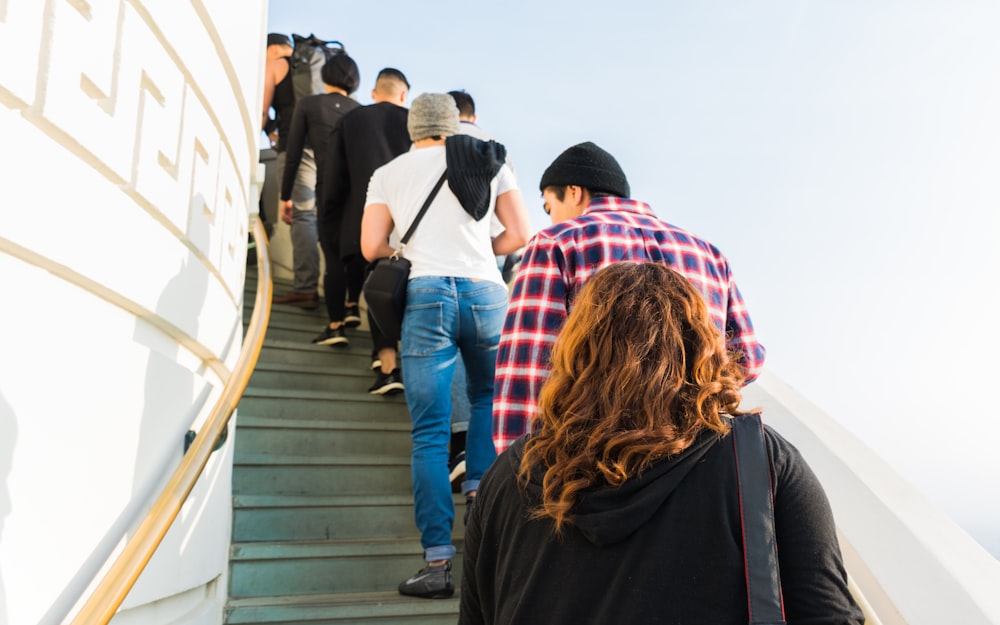 Gruppe von Menschen auf Treppen unter klarem weißen Himmel