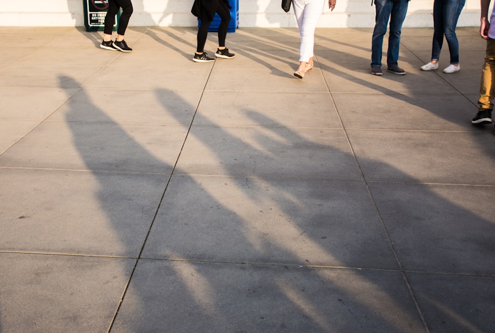 회색 콘크리트 타일 바닥에 서있는 사람들의 그룹