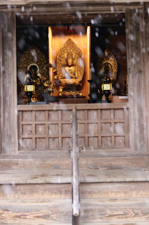 A serene temple altar displaying handcrafted spiritual keepsakes bathed in soft golden light