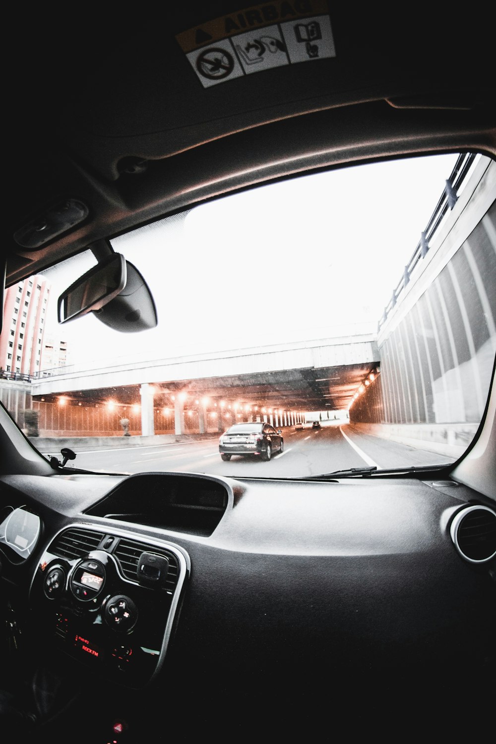 person inside vehicle talking photo of road near building